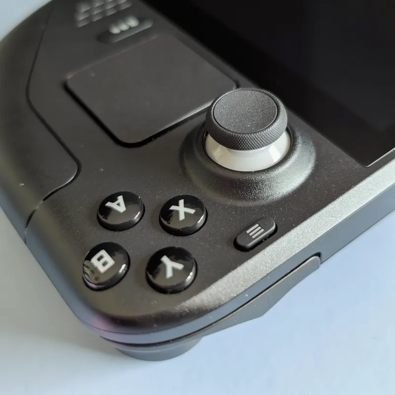 Close-up of the console's face buttons, thumbstick and trackpad
